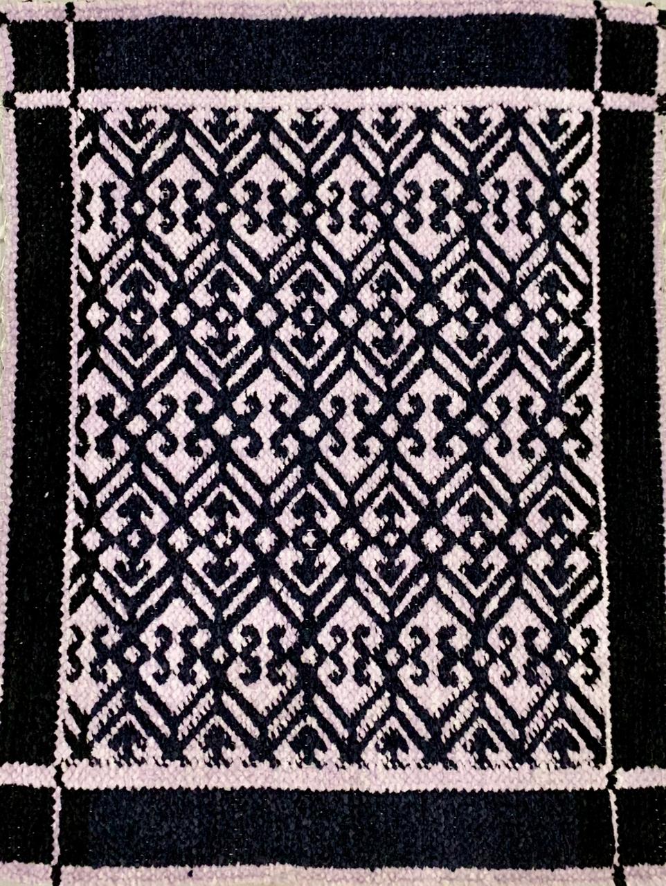 Black and white geometric patterned rug with a border