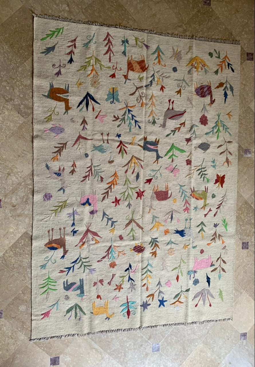 Colorful quilt with various patterns and designs on a beige background