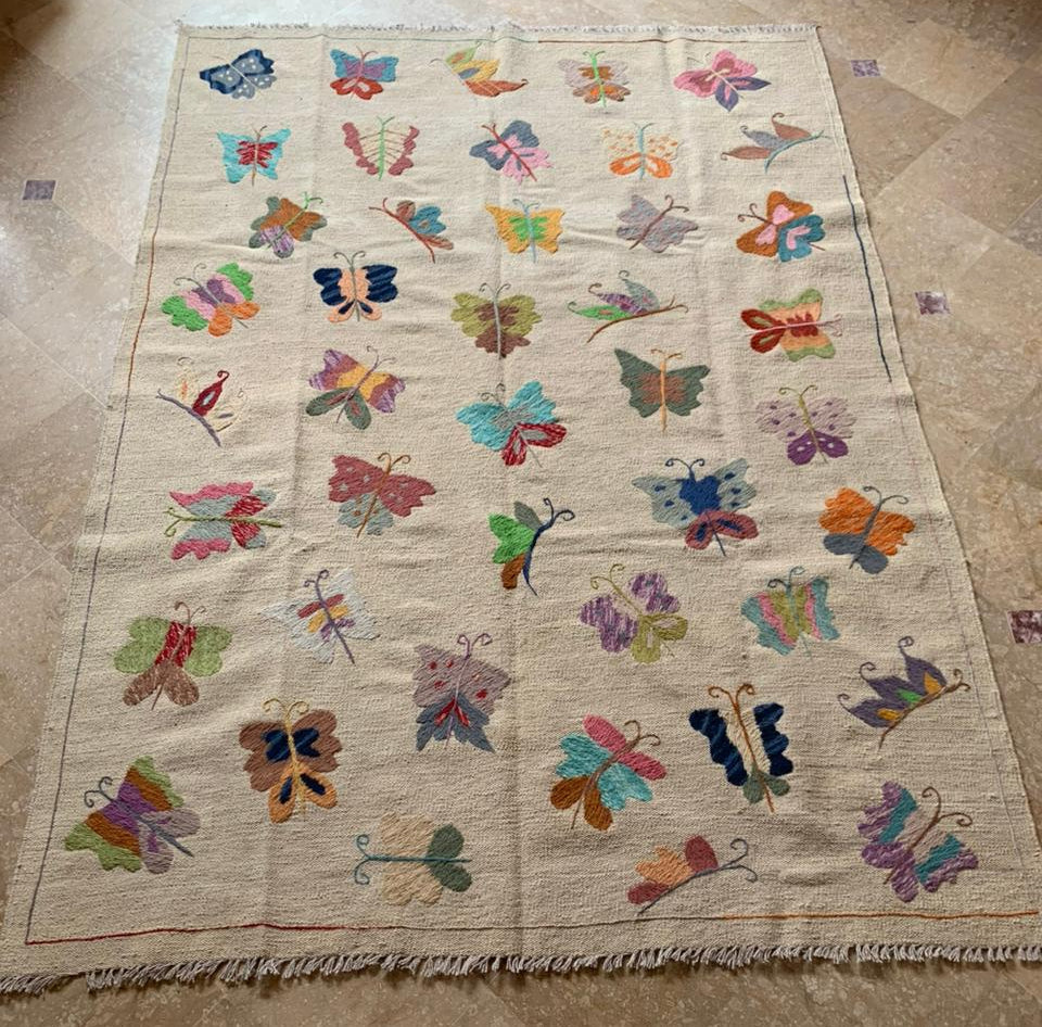 Quilt with colorful butterfly patterns on a beige background